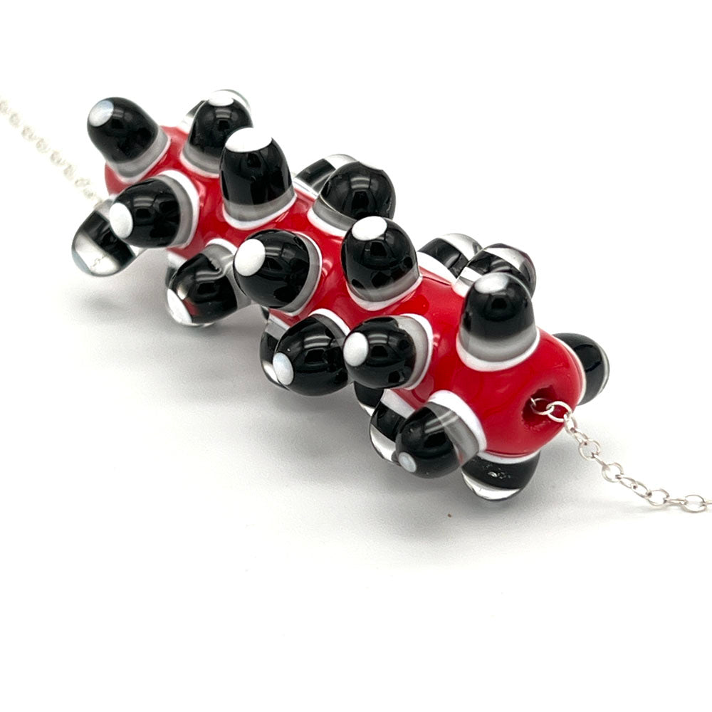 End view of bead showing how the dots are made up of layers of black, white and clear glass.