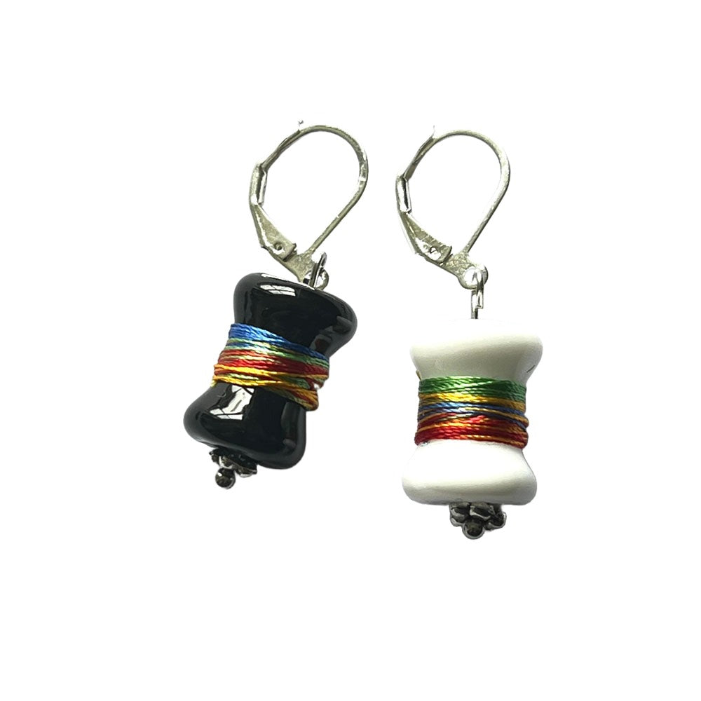 Black and white bobbin glass beads  wrapped with multicolour thread hanging from latch back hooks to create stitch markers.
