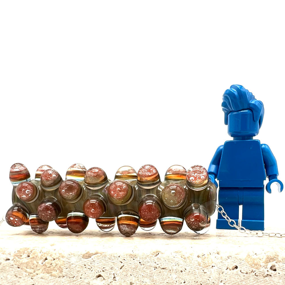 Blossom bead beside blue Lego figure for scale. The height of the bead brings it to the elbow of the figure.