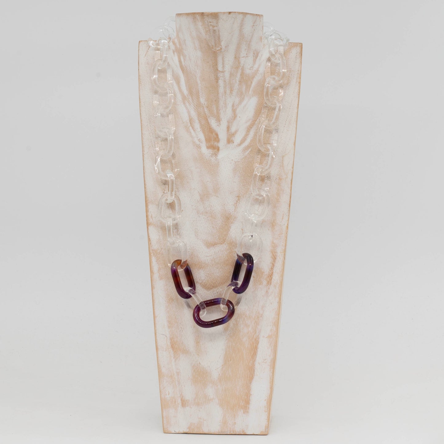 Front view of whitewashed wood torso displaying necklace made from clear glass links with 3 coloured links