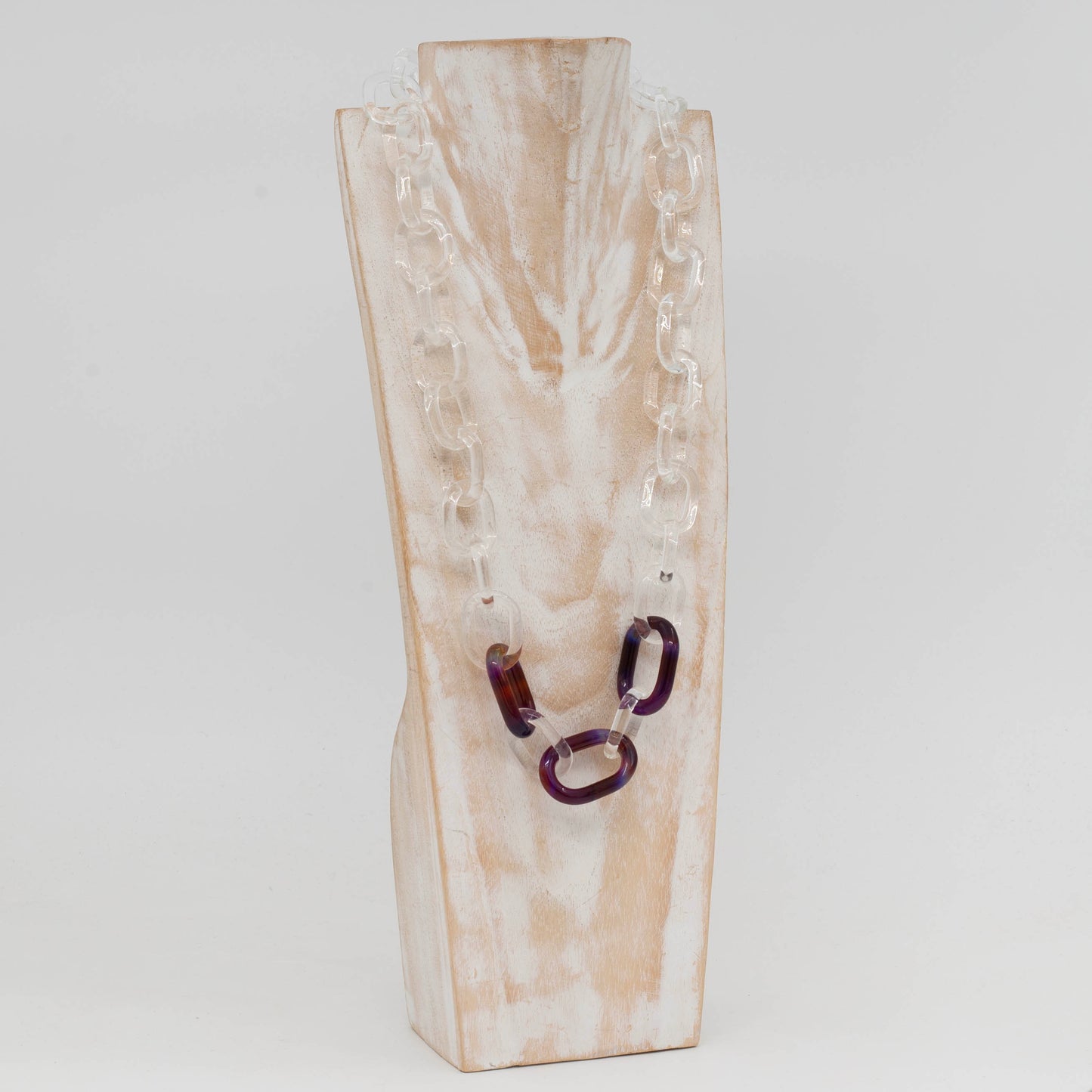 Side view of whitewashed wood torso displaying necklace made from clear glass links with 3 coloured links