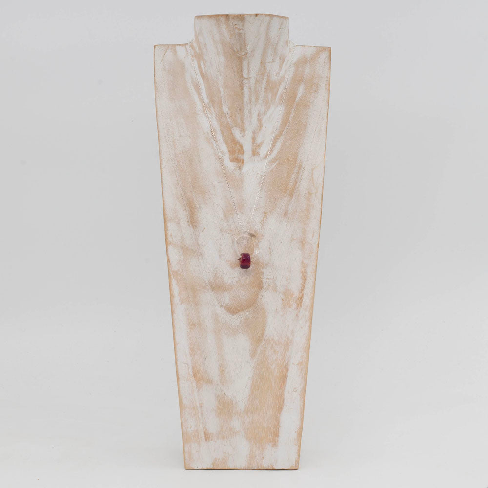 Whitewashed wood bust displaying a necklace made with a clear link and pink barrel bead.
