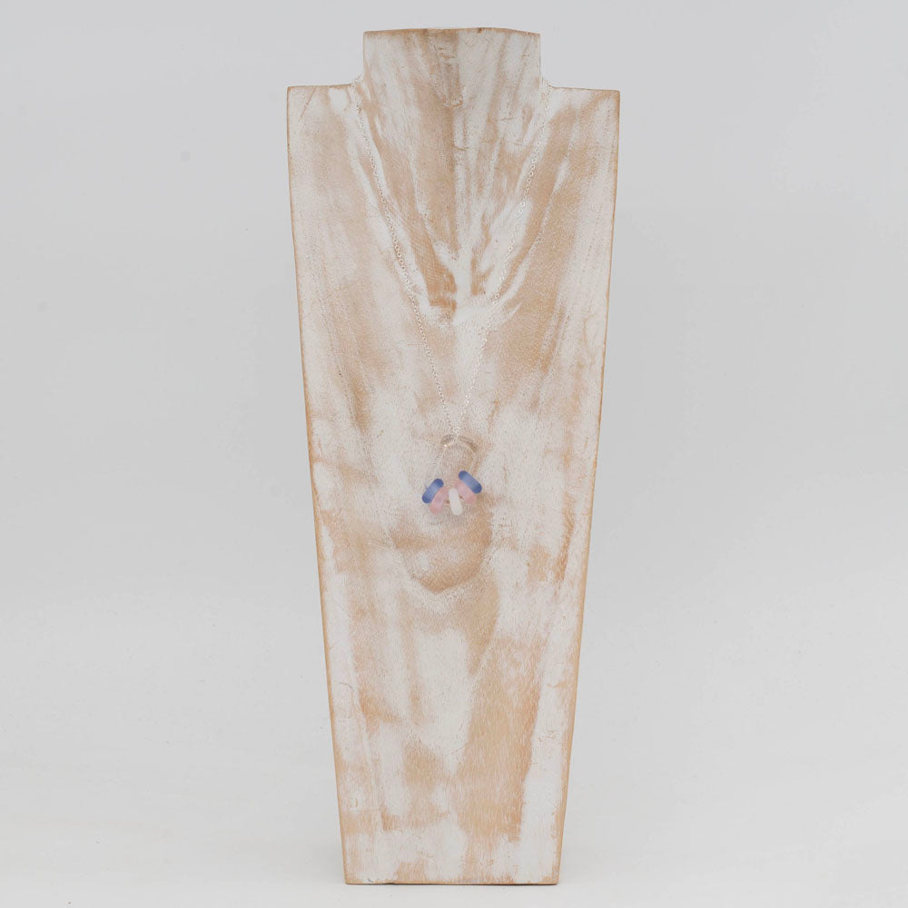 Whitewashed wood torso displaying a necklace with silver chain, clear glass links and pale blue, pink and white beads.