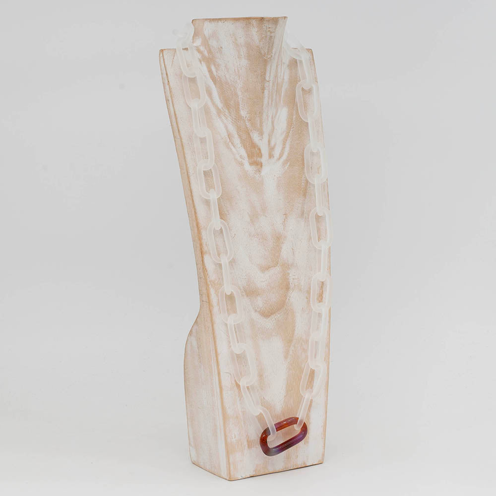 Side view of whitewashed wood torso  displaying a frosted clear glass chain link necklace with a single multi colour mai tai link
