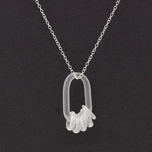 Close up of a clear glass link which passes through five clear glass beads. Both beads and link have a frosted finish.