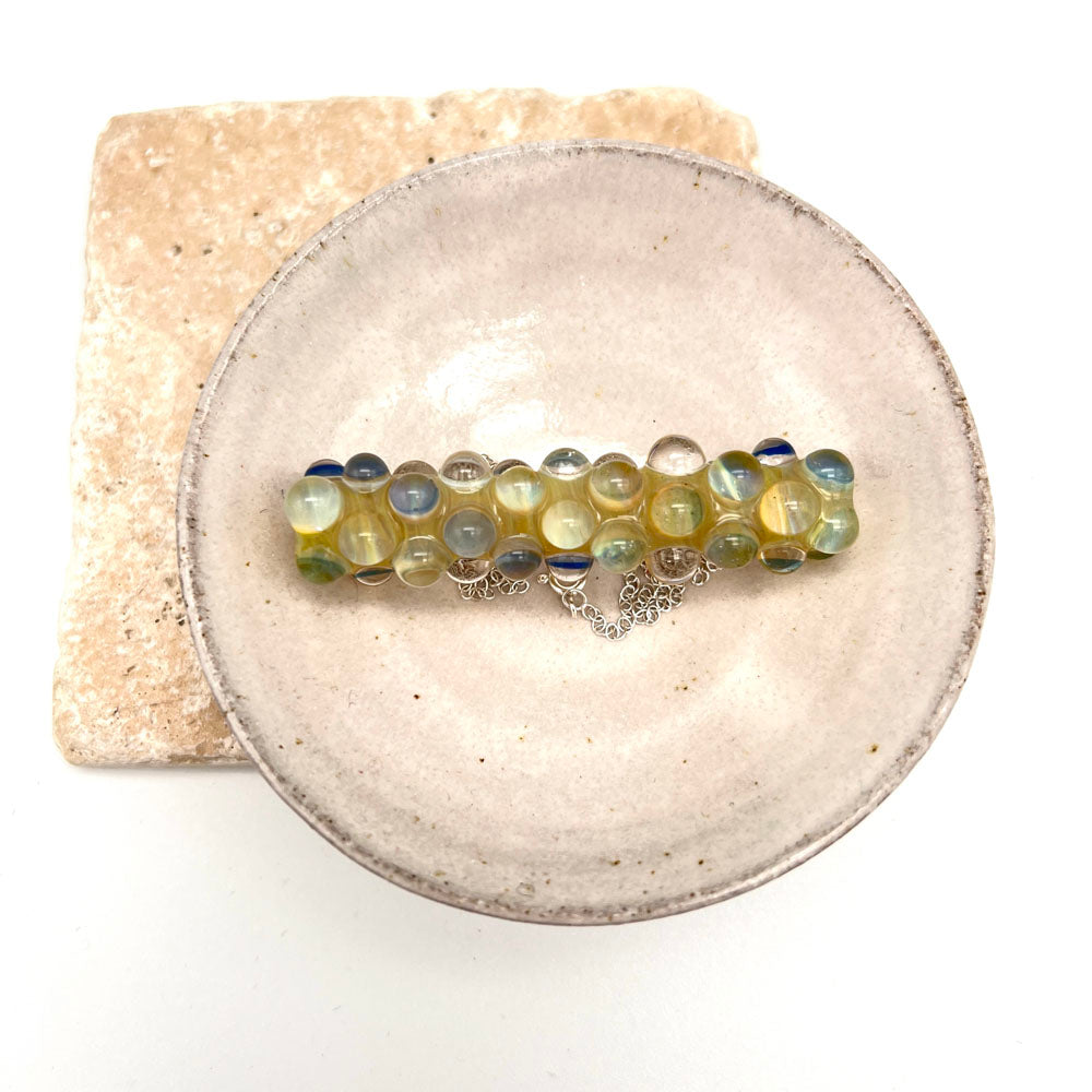 Lemonade bead necklace in a small white ceramic dish. Photographed from above.