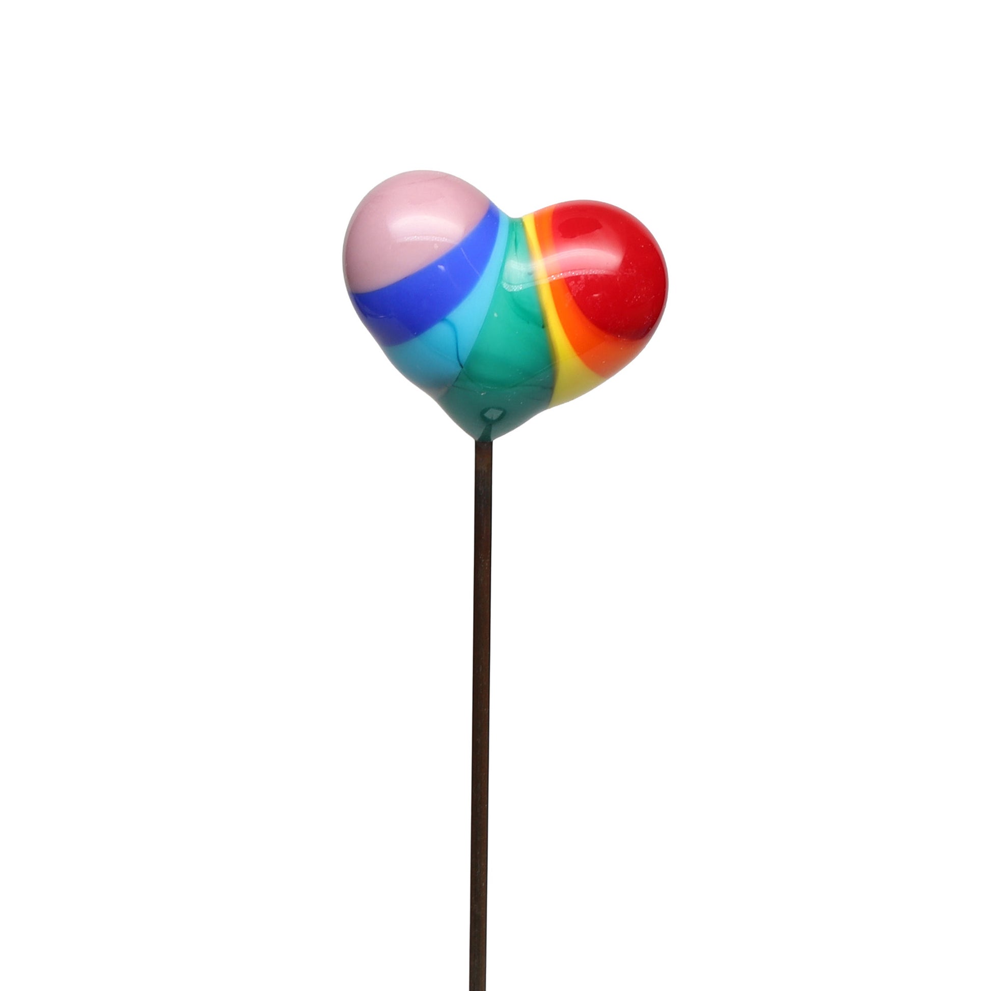 Close-up front view of a handmade rainbow glass heart plant decoration on a white background. The heart shows bold opaque rainbow stripes and is mounted on a slim metal stake