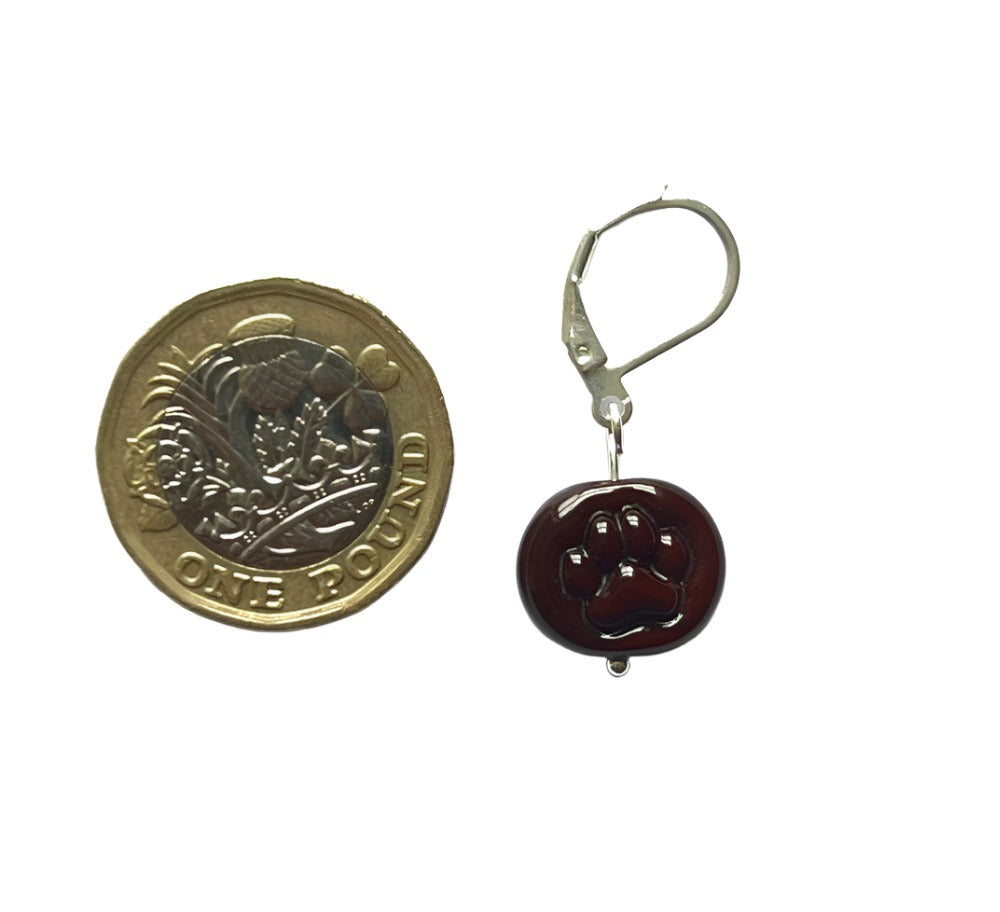 Brown bead with paw print imprint  on a latch back hook  stitch marker shown with a pound coin for scale