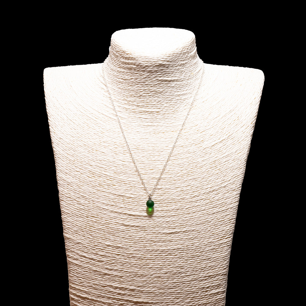 green glass ball charm necklace with sterling silver chain shown on a white mannequin bust