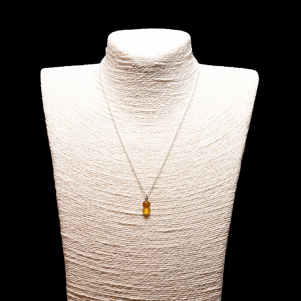 yellow glass ball charm necklace with sterling silver chain shown on a white mannequin bust