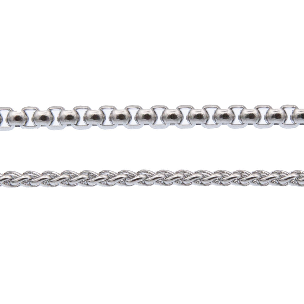 Close up of two stainless steel chains. The rolo chain is made with chunky square links and the what chain with finer links which are arrange in a plaited pattern