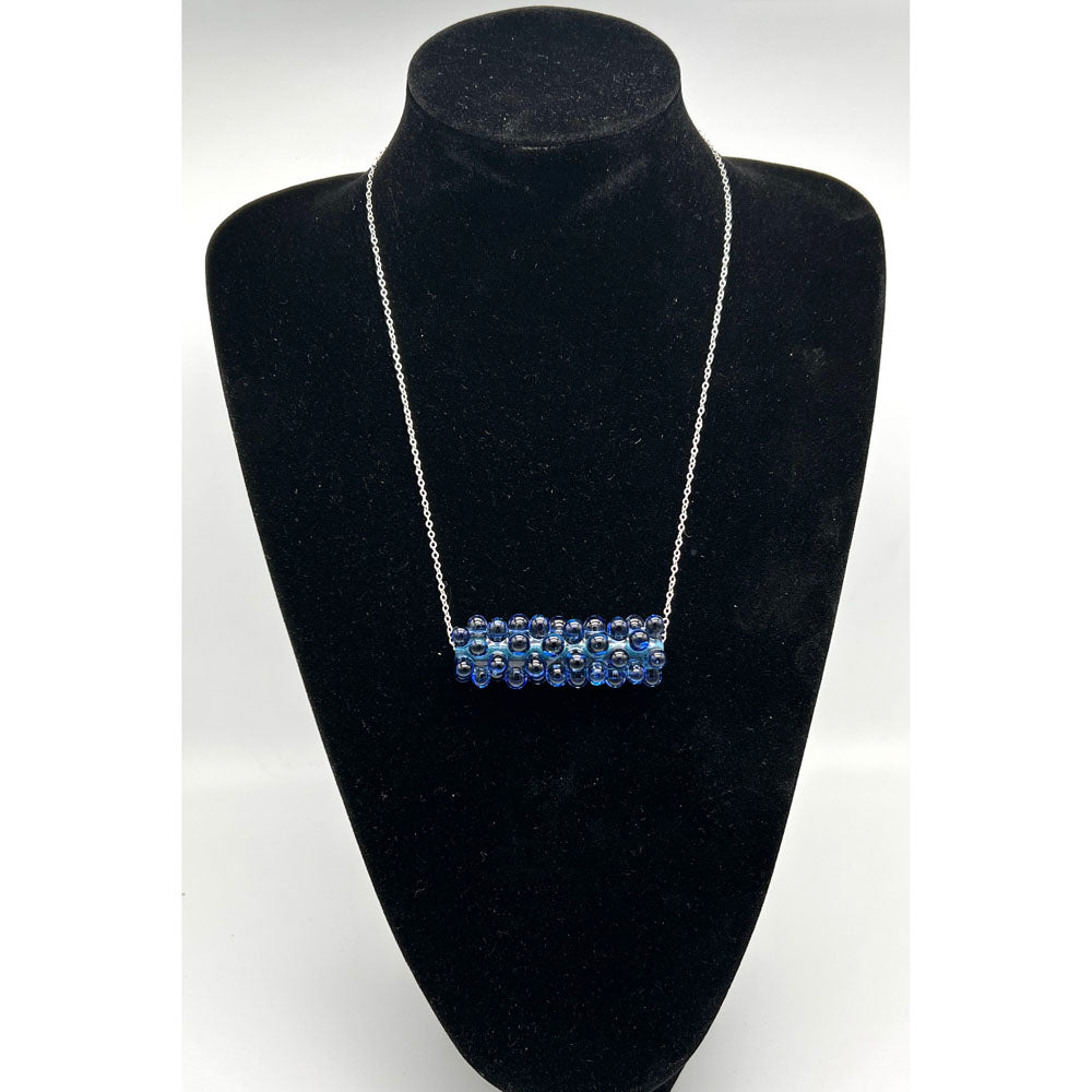 Black velvet bust displaying the blue ripples raised dot necklace