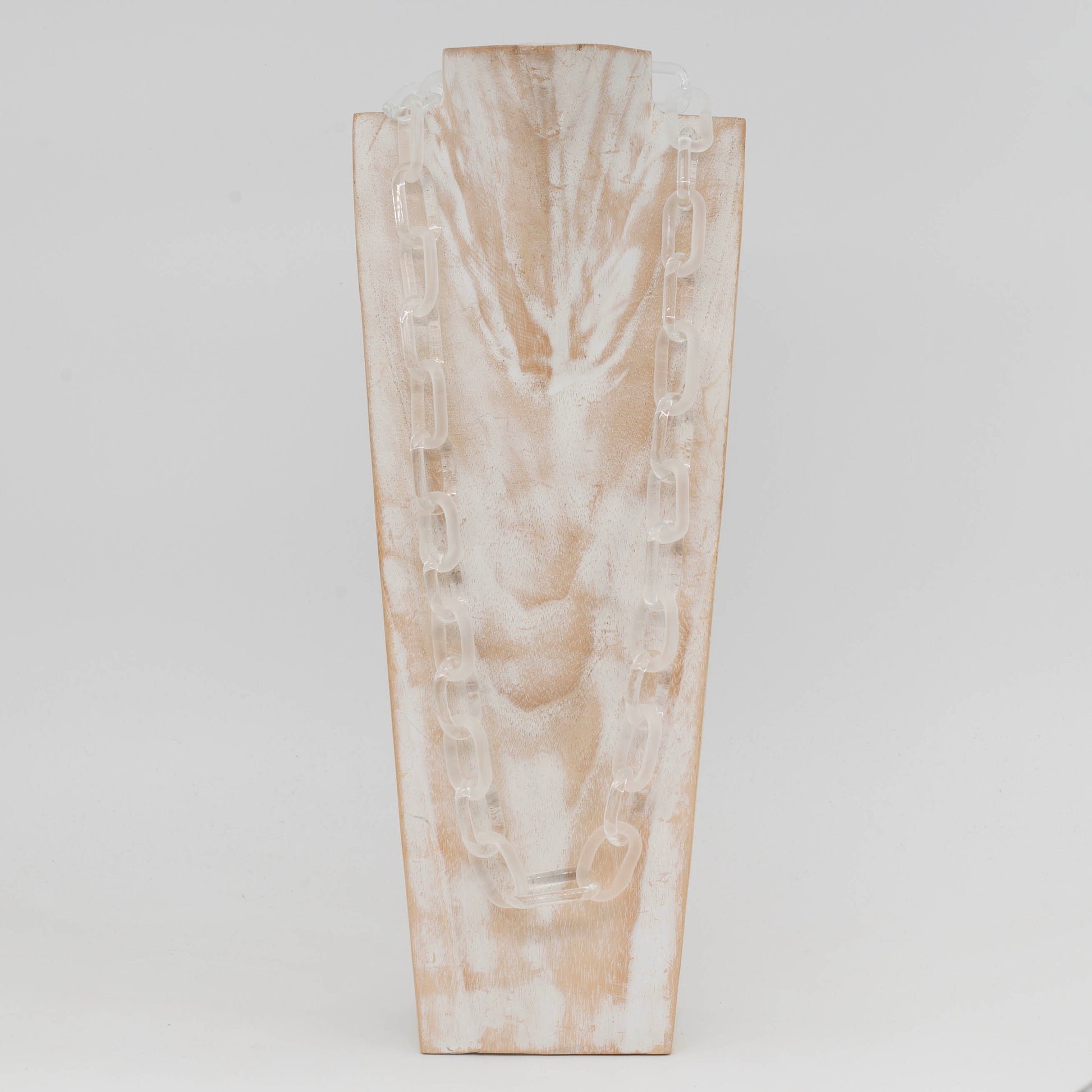 Whitewashed wood torso displaying a glass necklace made with bold links of alternating clear and frosted glass