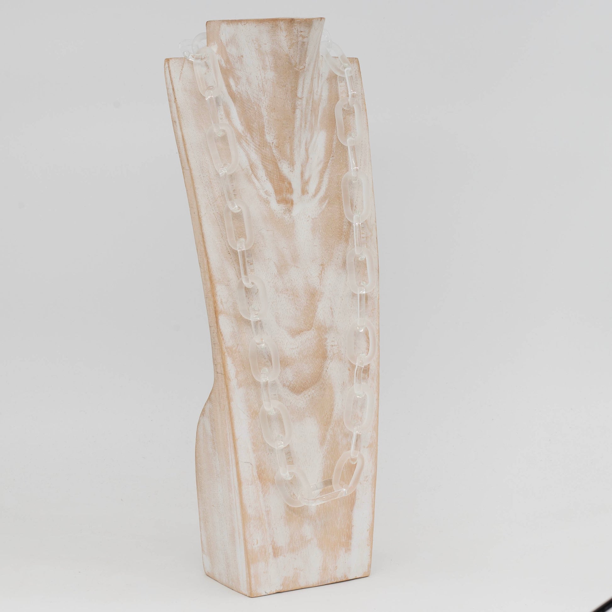 Side view of whitewashed wood torso glass displaying necklace made with bold links of alternating clear and frosted glass
