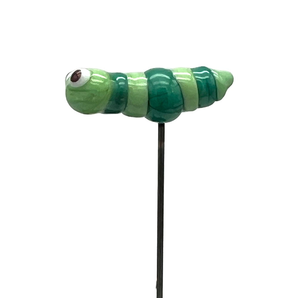 A glass caterpillar plant decoration on a stake, viewed from the side, showing its light and dark green striped body.