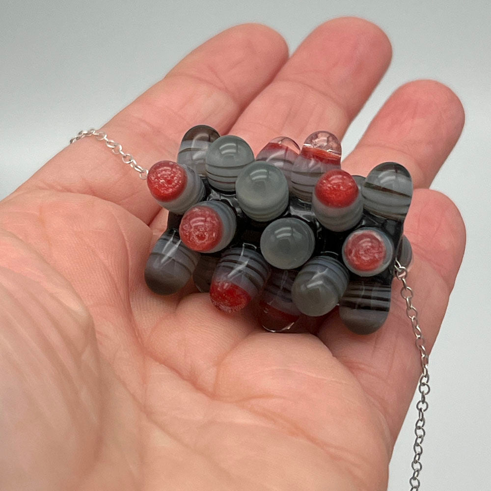 Chunky rock bead shown in the palm of a hand.