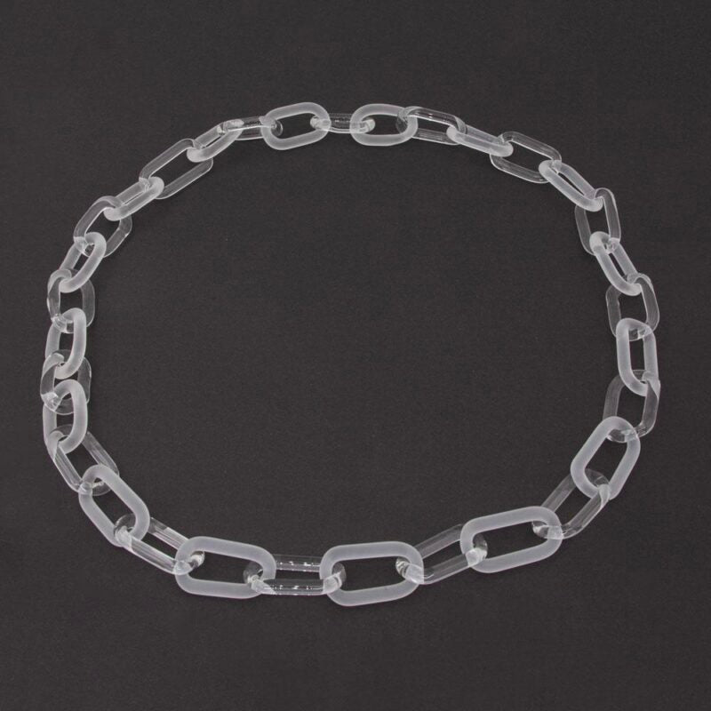 Necklace made from alternating links of clear and frosted glass, dark background