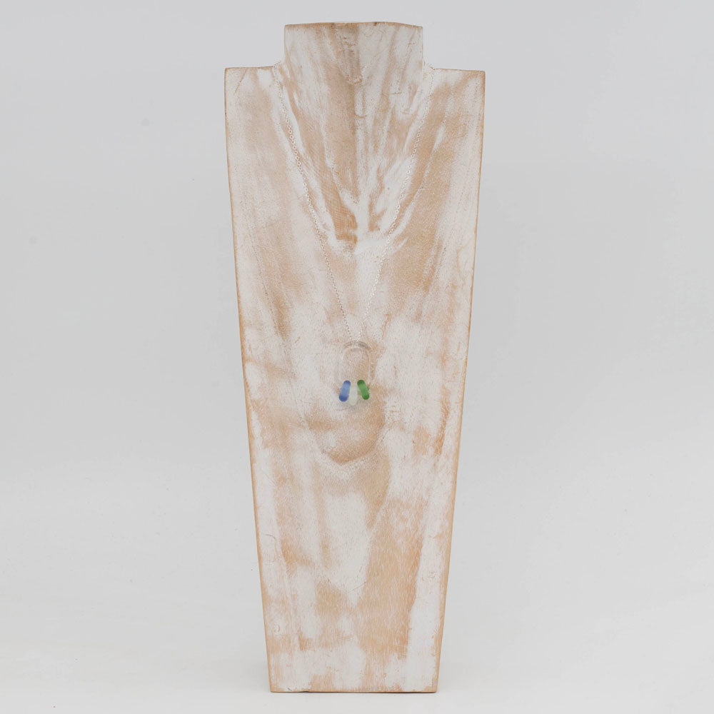 Whitewashed wood torso displaying a necklace with clear glass link and three coloured beads.