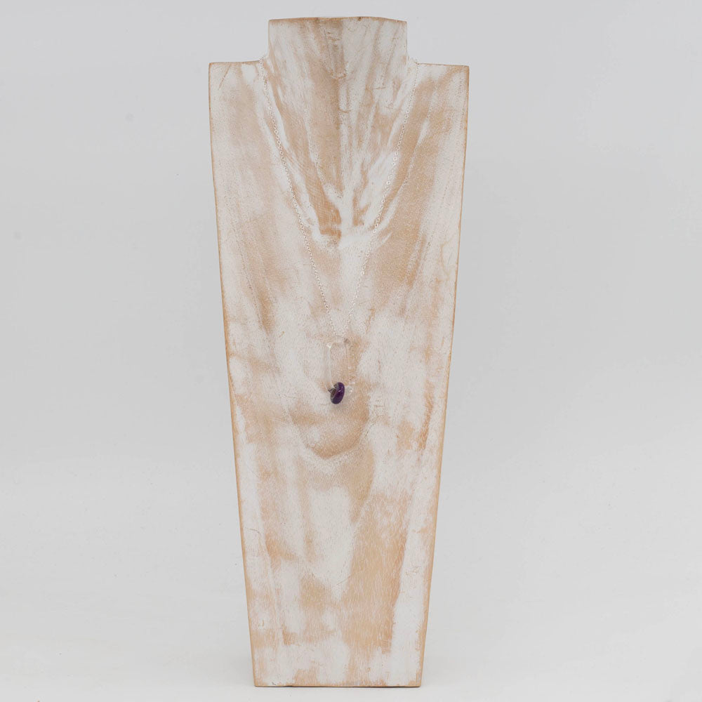 Whitewashed wood torso displaying a necklace with clear glass link which passes though a purple bead.