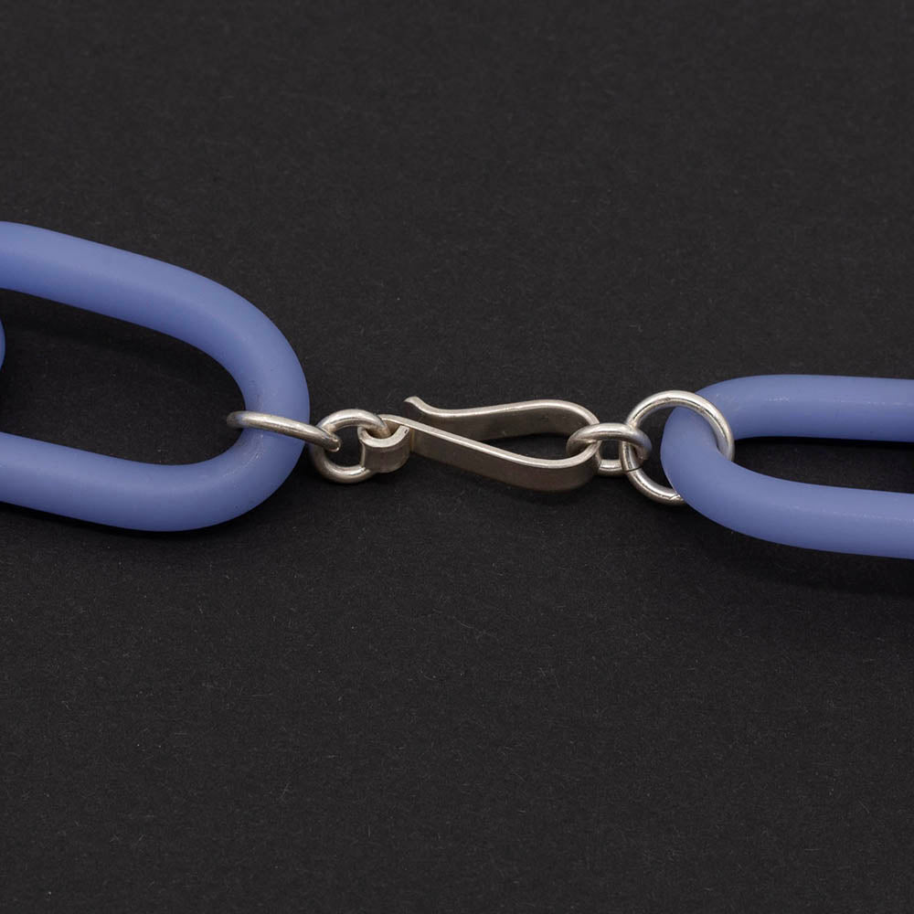 Close up of sterling silver hook and eye clasp on blue glass necklace