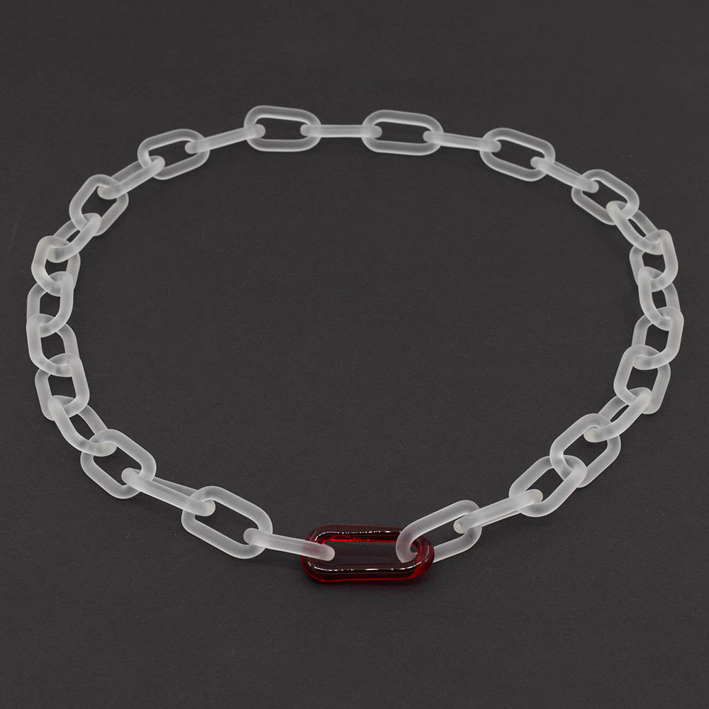 Frosted clear glass chain necklace with single red link on dark background