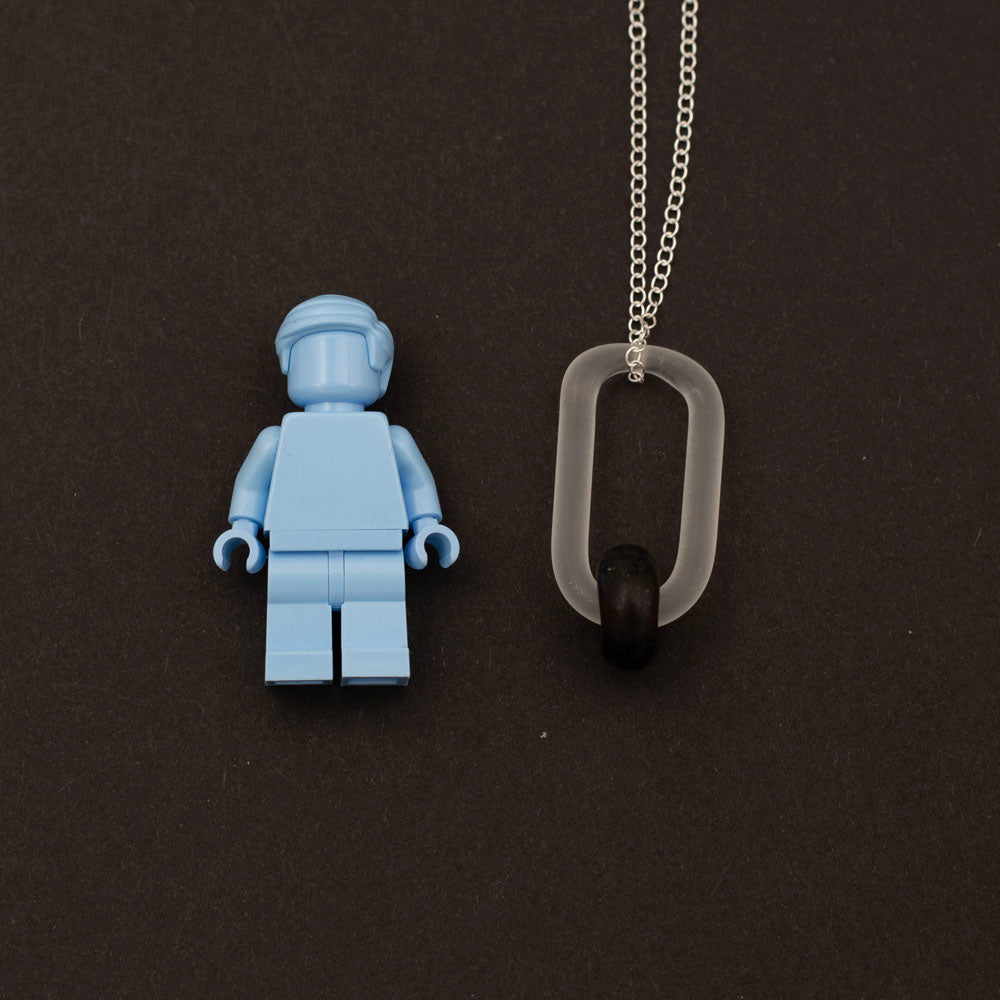 Lego figure with a necklace with clear link and dark brown bead made from a recycled beer bottle