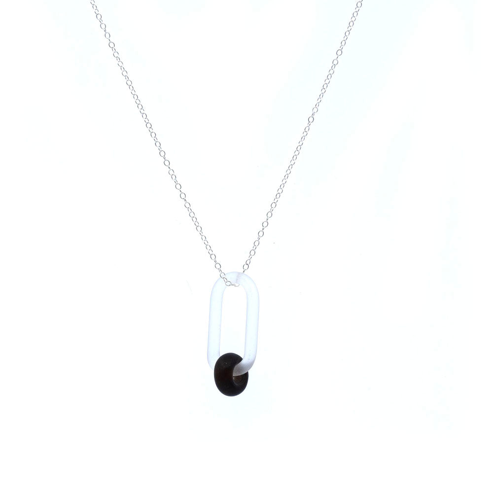 Necklace with clear link and dark brown bead made from a recycled beer bottle, white background