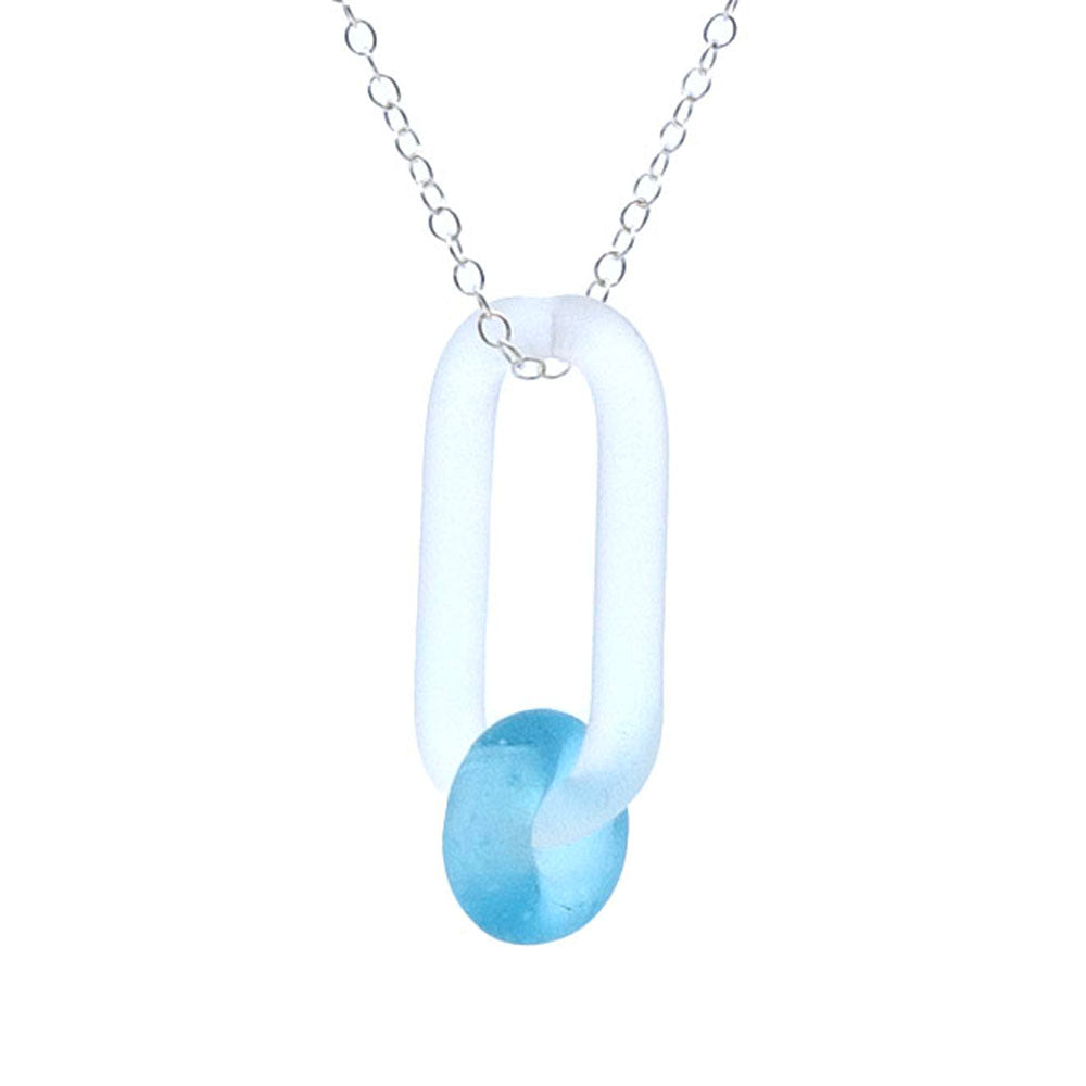 Close up of a frosted clear glass link. The link is oval and passes through a bead made from turquoise Bombay Sapphire gin bottle glass, The link hangs from a sterling silver chain.