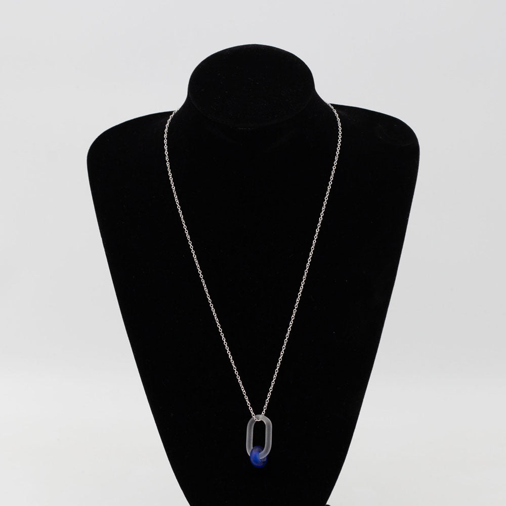 Black velvet bust displaying frosted clear glass link necklace. The link passes through a bead made form recycled blue sherry bottle glass, and the bead has a frosted finish. The link hangs from a sterling silver chain.