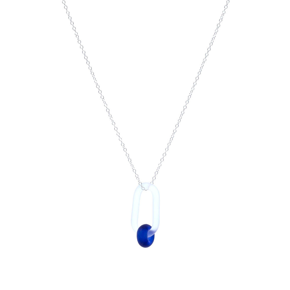 White background. Frosted clear glass link necklace. The link passes through a bead made form recycled blue sherry bottle glass, and the bead has a frosted finish. The link hangs from a sterling silver chain.