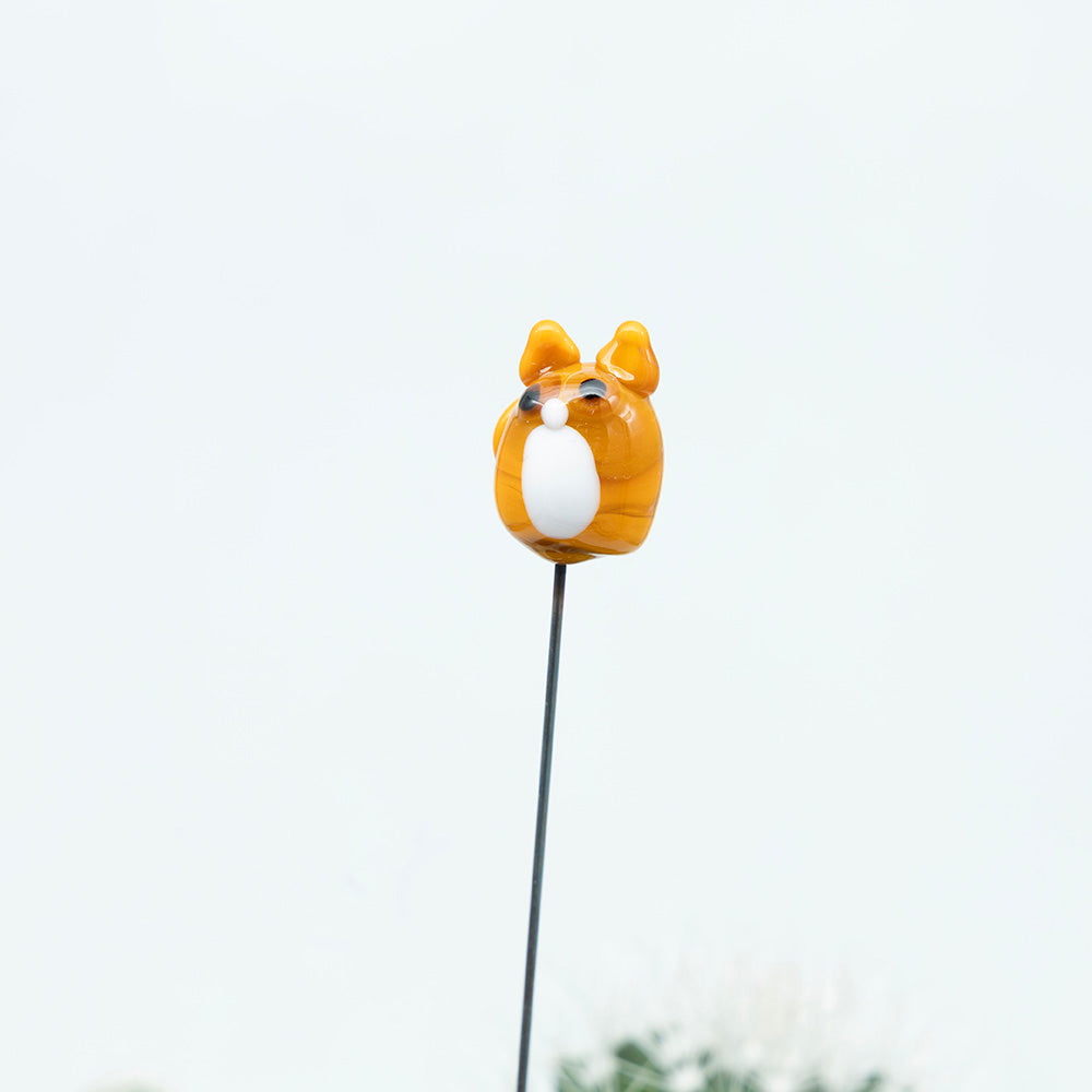 close up of ginger glass cat with white bib and amber eyes on a metal stake