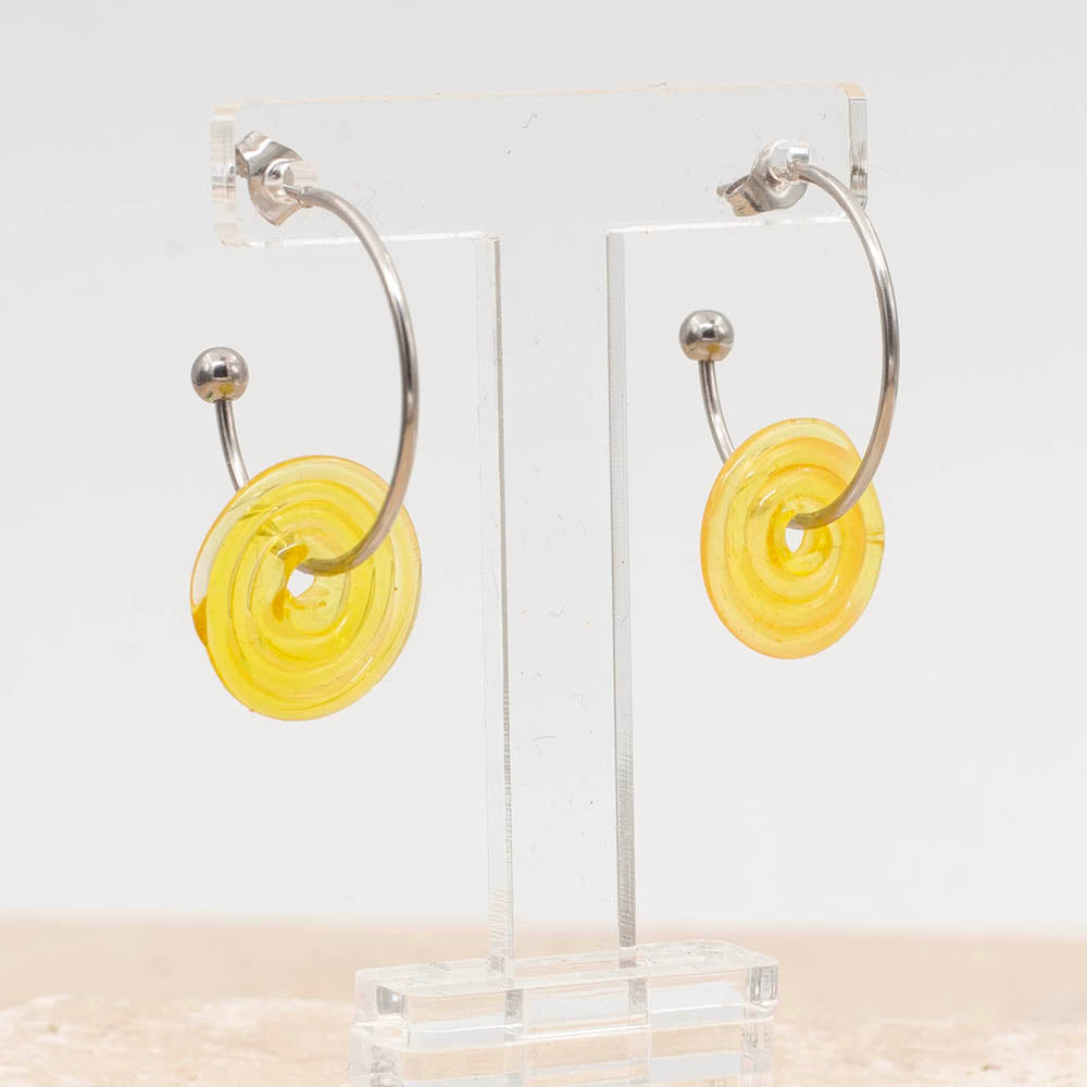 Half front view of a pair of stainless steel hoop earrings with yellow glass disc beads