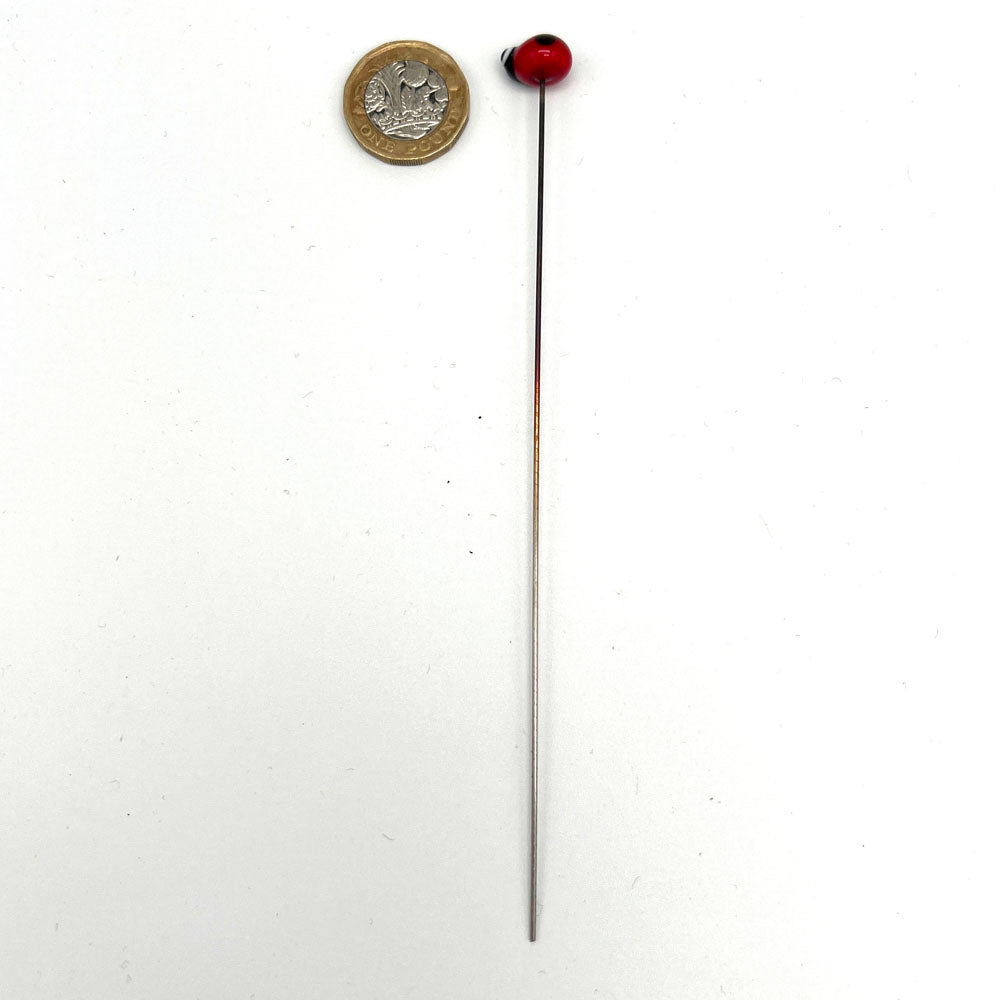 Glass ladybird plant decoration on a metal stake next to a pound coin for scale, by Joy McMillan Glass