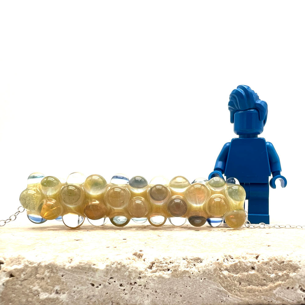 Lemonade bead necklace in front of a Lego figure for scale. The height of the bead comes to the waist of the figure.