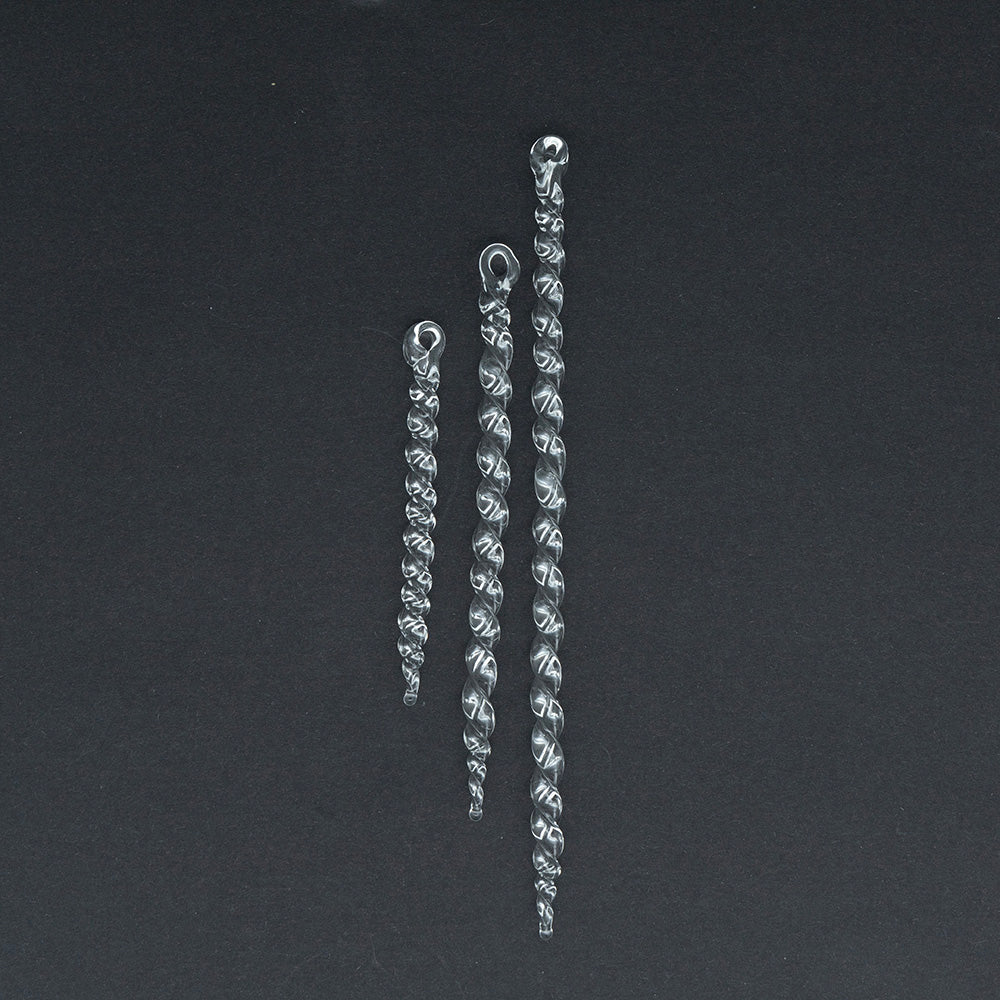 Three clear glass icicles on dark background. The icicles are made from delicate glass rods and have twists along their length. There are theww length os icicle - small, medium and large.