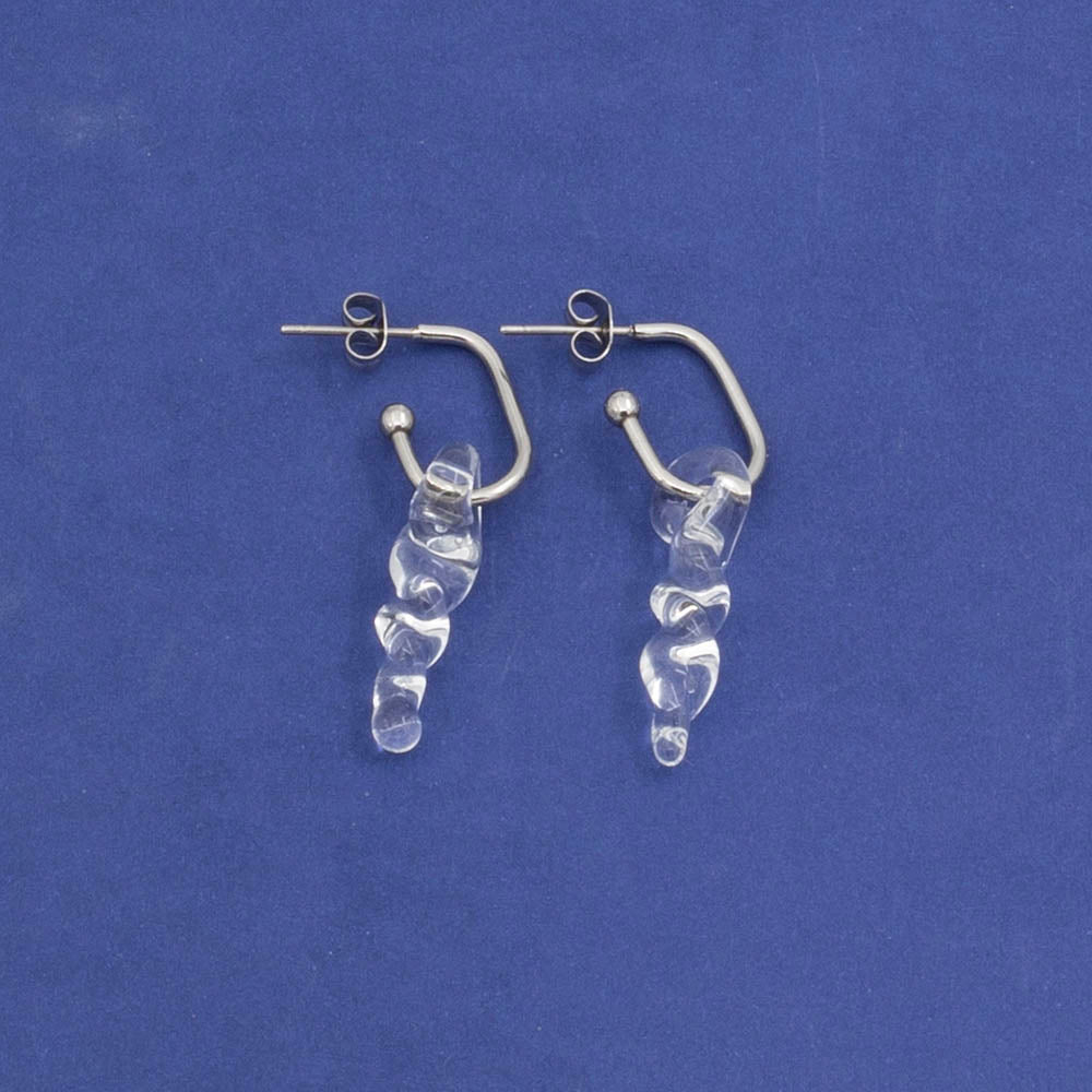 oval hoop earring with small glass icicle drops on blue background