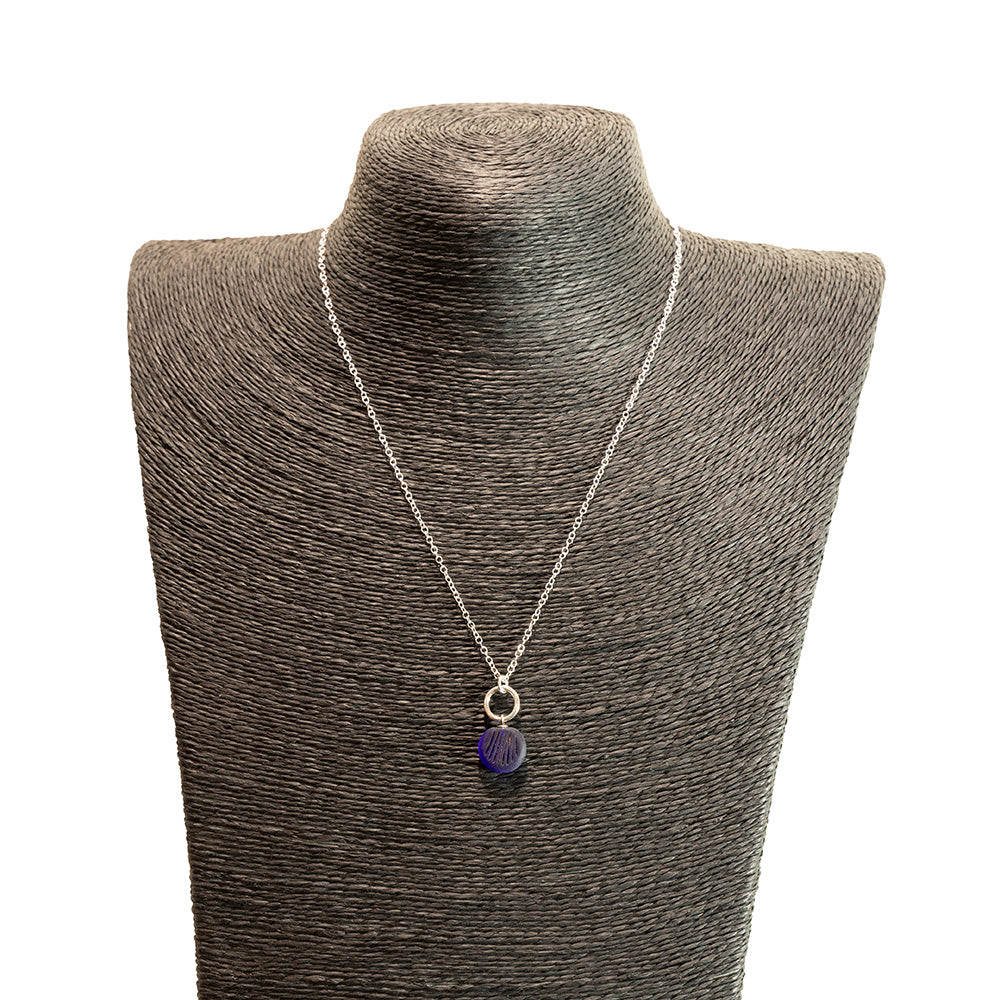 dark blue glass shell imprint charm necklace with sterling silver chain shown on a black mannequin bust