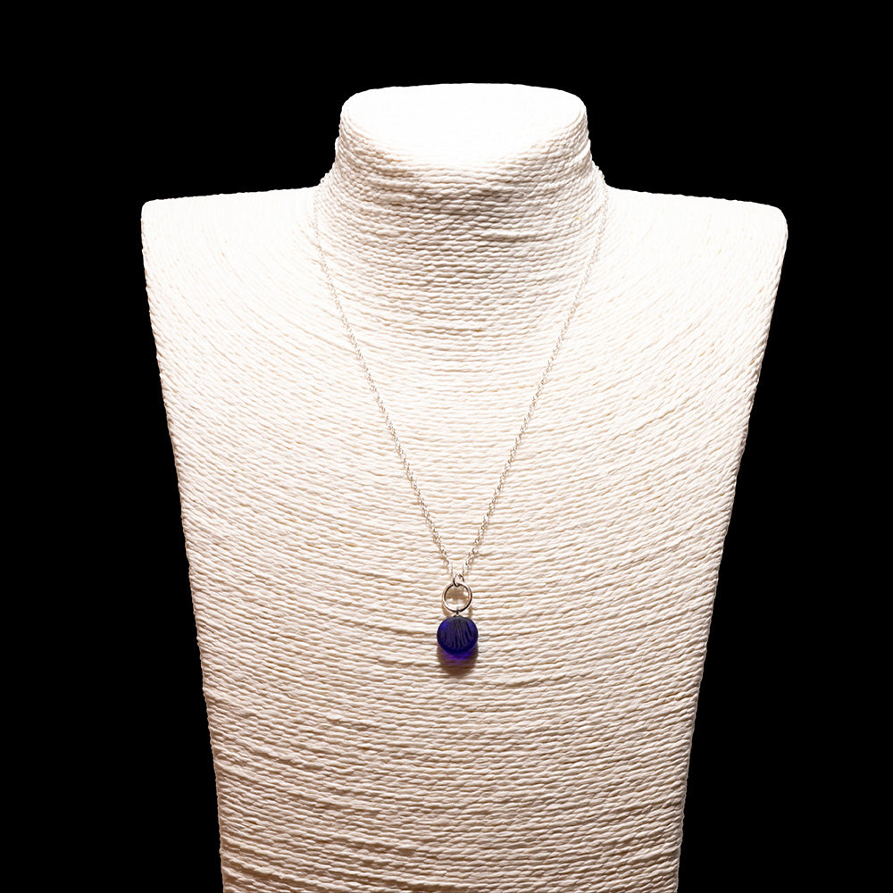 dark blue frosted glass shell imprint charm necklace with sterling silver chain shown on a white mannequin bust