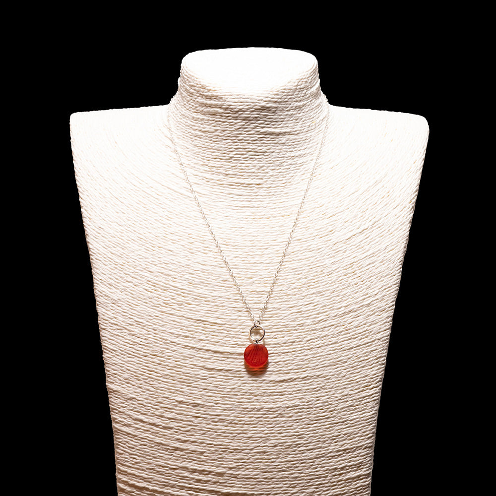 orange frosted glass shell imprint charm necklace with sterling silver chain shown on a white mannequin bust