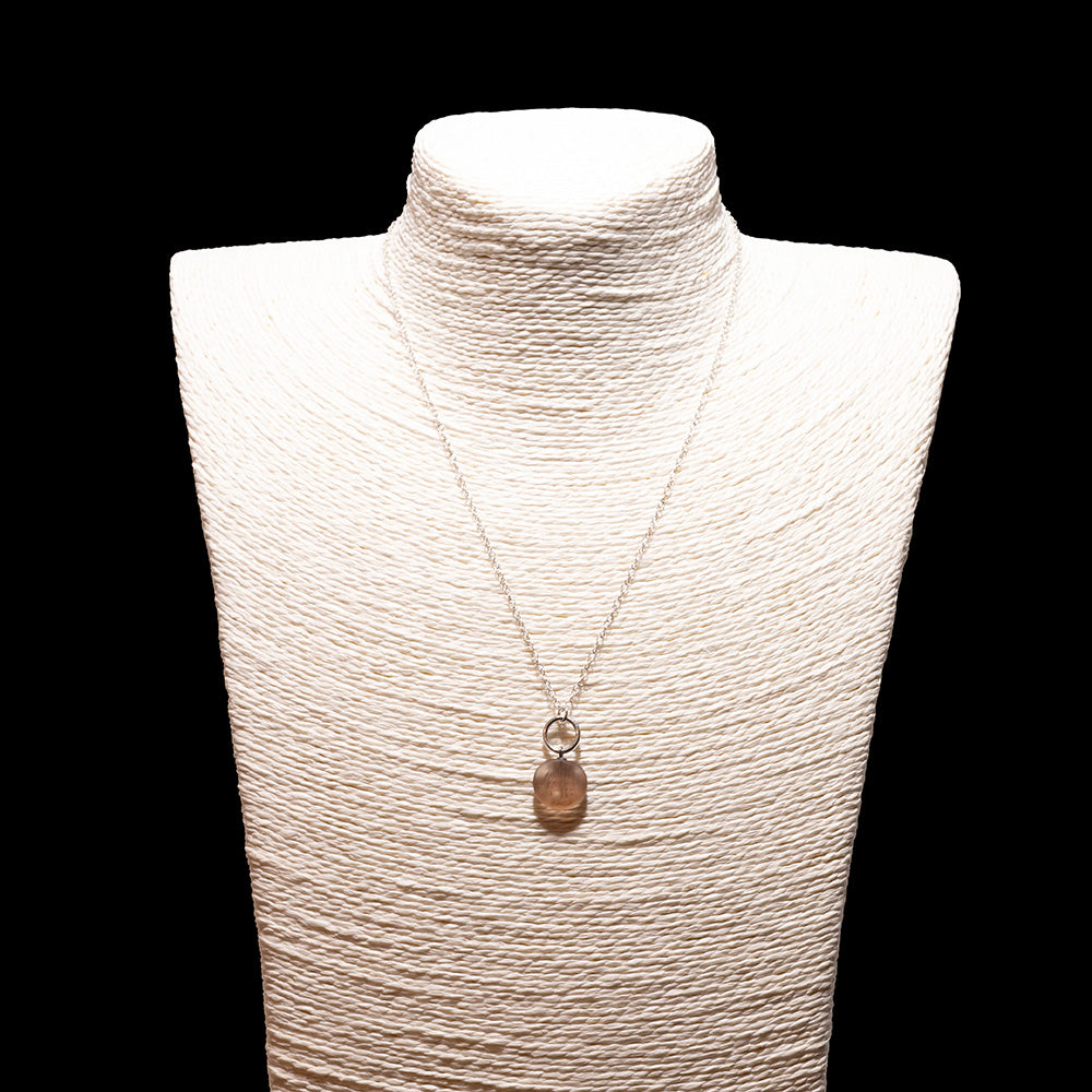 pink frosted glass shell imprint charm necklace with sterling silver chain shown on a white mannequin bust