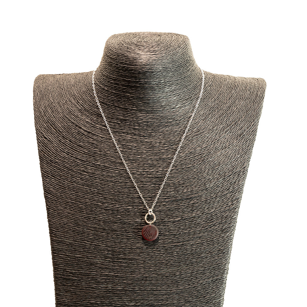 red glass shell imprint charm necklace with sterling silver chain shown on a black mannequin bust