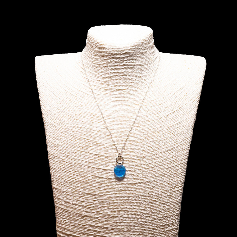 turquoise frosted glass shell imprint charm necklace with sterling silver chain shown on a white mannequin bust