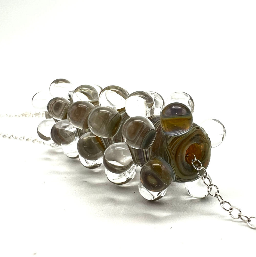 End view of Strata glass bead necklace showing how the glass dots are arranges as they move along the bead. Dots are placed so one round sits in the space left by the previous round.