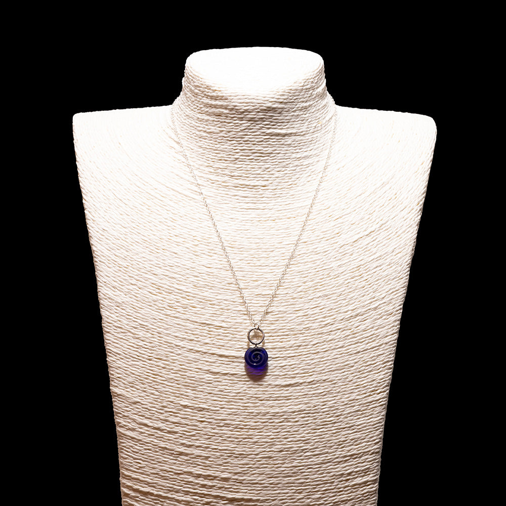 dark blue glass swirl charm necklace with sterling silver chain shown on a white mannequin bust