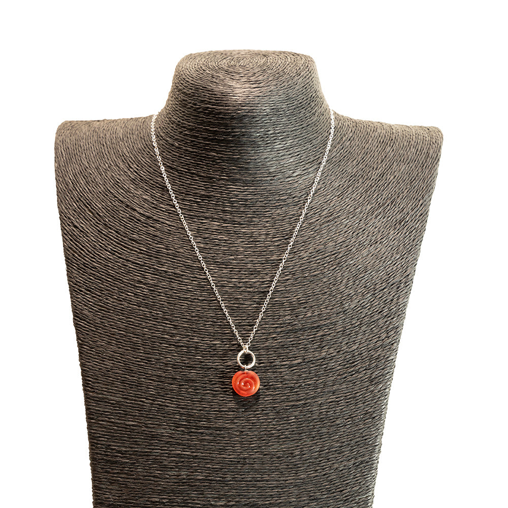 orange swirl charm necklace shown on a black mannequin bust