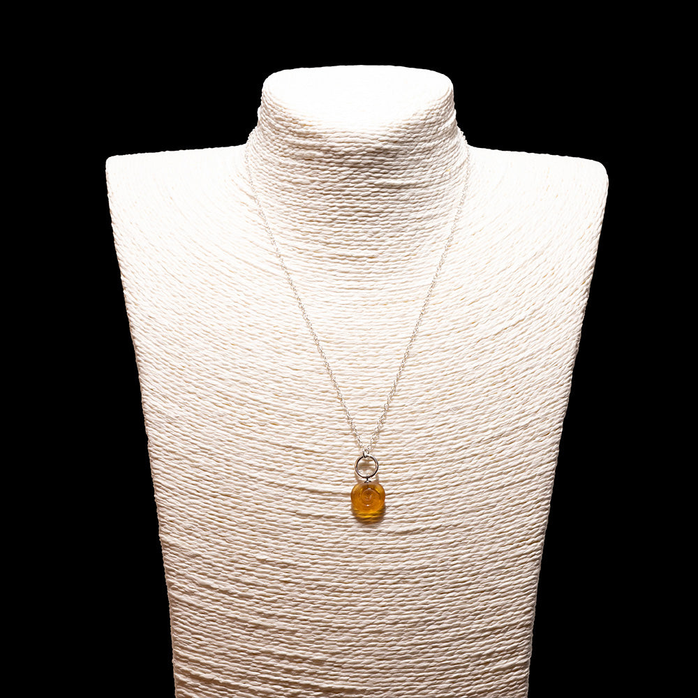 yellow glass swirl charm necklace with sterling silver chain shown on a white mannequin bust