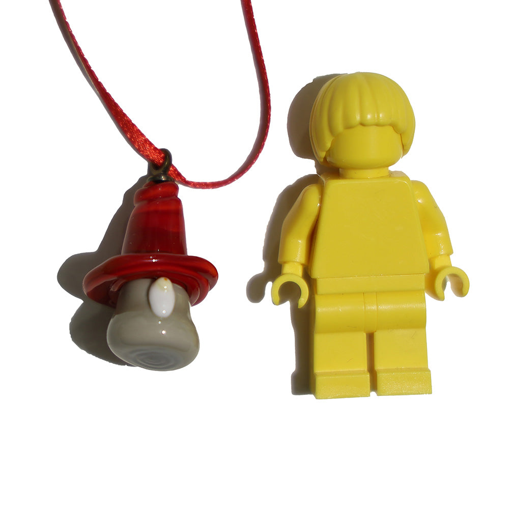 Tiny glass gnome decortaion shown with a lego figure for scale.