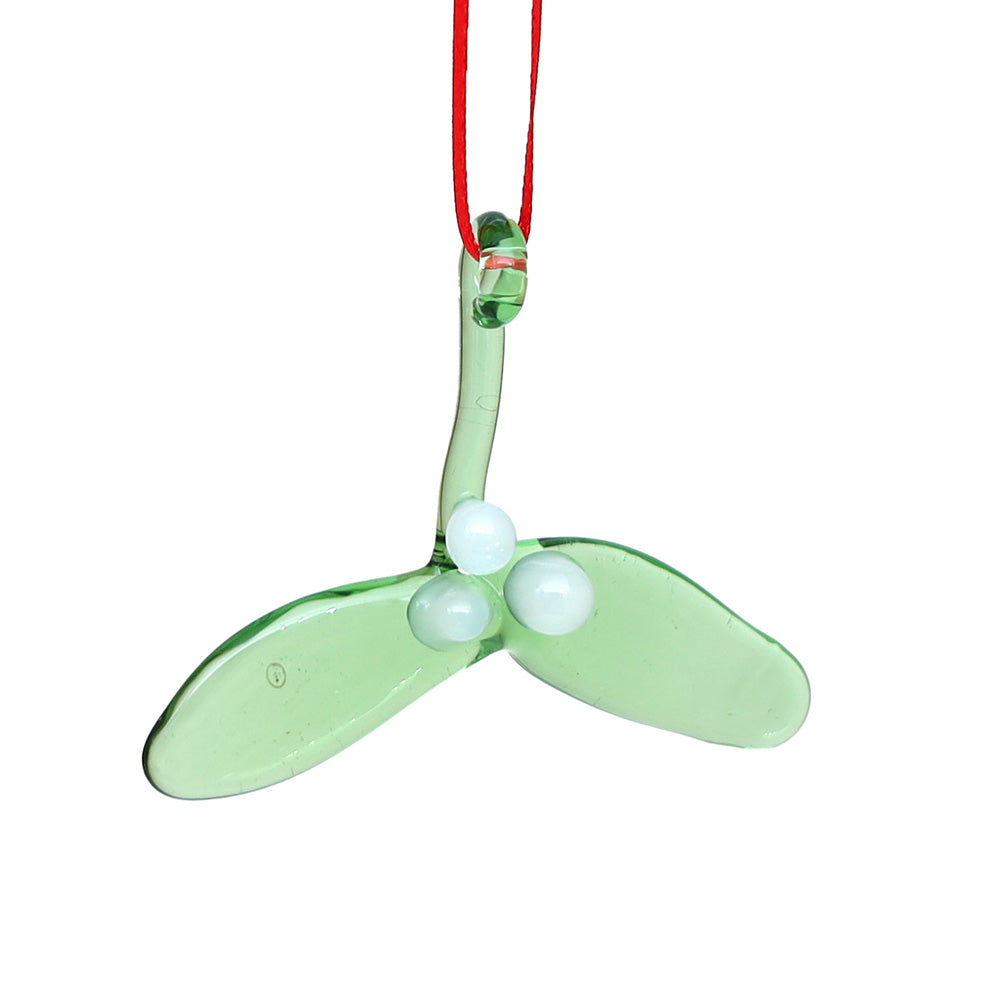 Glass mistletoe decoration with green leaves and three white berries hanging on a red ribbon.