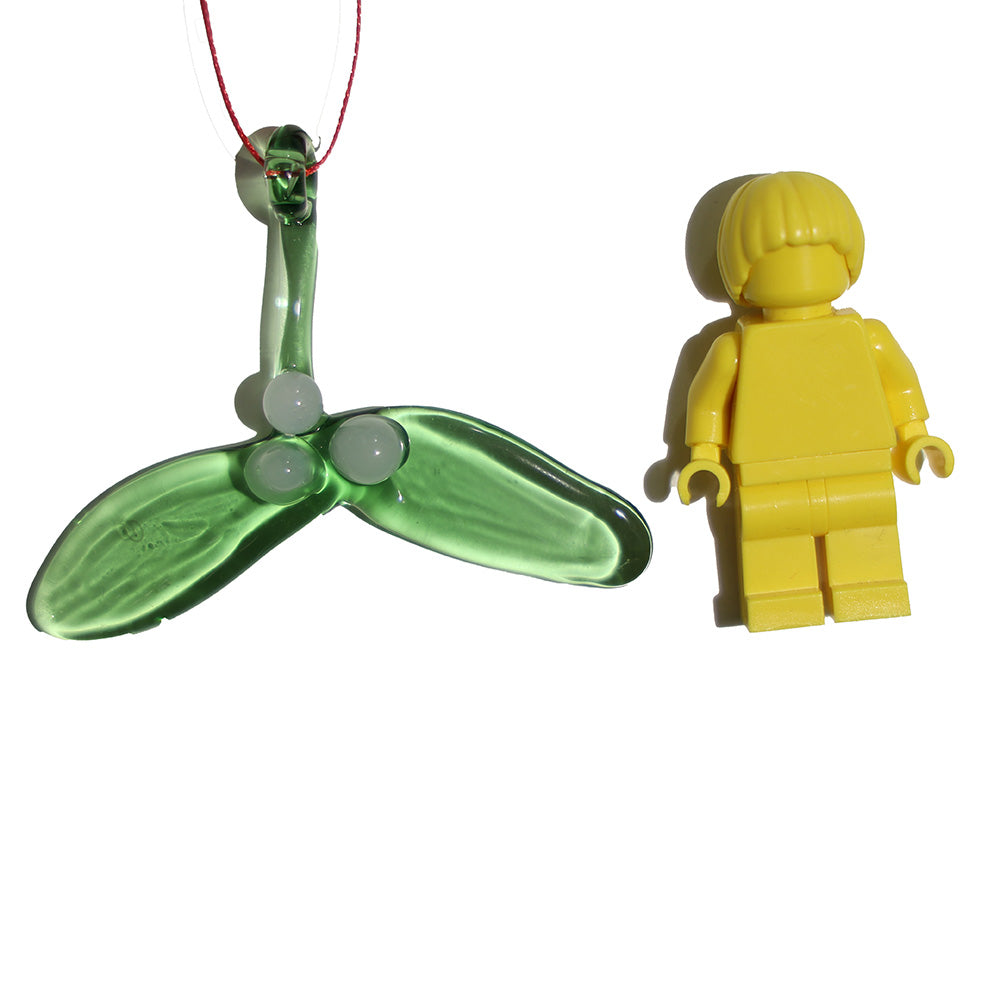 Tiny glass mistletoe decorations shown with a lego figure for scale.