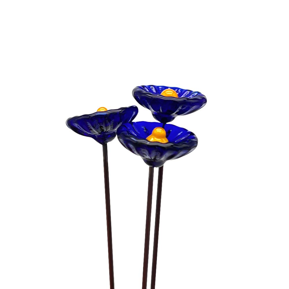 three transparent dark blue glass daisies with yellow centres on metal stakes